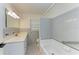 Bathroom with light grey tile, a bathtub and double vanity at 1625 Bravo Dr, Clearwater, FL 33764