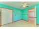 Teal bedroom with wood trim, ceiling fan and built-in closet at 1625 Bravo Dr, Clearwater, FL 33764