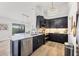 Modern kitchen with dark cabinetry, marble countertops, and stainless steel appliances at 1649 Manor Rd, Englewood, FL 34223