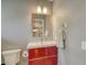 This bathroom has an updated sink with a red cabinet and a matching-framed mirror at 1705 Shoreland Dr, Sarasota, FL 34239