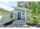 Welcoming front entrance with a covered porch, lush landscaping, and unique architectural details at 1705 Shoreland Dr, Sarasota, FL 34239