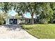 Charming single-story home featuring a large shade tree and a brick driveway with a two-car garage at 1705 Shoreland Dr, Sarasota, FL 34239