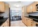 Kitchen with wood cabinets, black countertops, stainless steel appliances, and a view to the dining room at 1705 Shoreland Dr, Sarasota, FL 34239