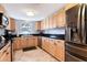 Well-lit kitchen with stainless steel appliances, granite countertops, and light wood cabinetry at 1705 Shoreland Dr, Sarasota, FL 34239