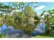 Scenic pond view with lush trees, a wooden dock, and reflections on the calm water at 1705 Shoreland Dr, Sarasota, FL 34239