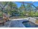 This relaxing backyard offers a screened-in pool and a cozy hammock surrounded by mature trees at 1705 Shoreland Dr, Sarasota, FL 34239