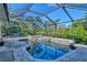 A luxurious screened-in pool area with a waterfall feature and lush tropical landscaping at 1705 Shoreland Dr, Sarasota, FL 34239