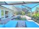 Inviting pool area with lounge chairs, a screened enclosure, and a beautiful stone waterfall at 1705 Shoreland Dr, Sarasota, FL 34239