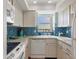 Well-equipped kitchen with blue mosaic backsplash at 1770 Benjamin Franklin Dr # 407, Sarasota, FL 34236