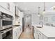 Bright kitchen featuring white cabinets, stainless steel appliances, and an eat-in island at 17722 Littleton Pl, Lakewood Ranch, FL 34202