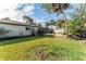 Large backyard with grassy area and tropical landscaping at 180 Aurora Rd, Venice, FL 34293