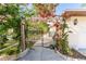 View of a charming backyard gate with a pergola covered in blooming flowers at 180 Aurora Rd, Venice, FL 34293