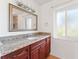 Bathroom with granite countertop, wood cabinets, and a window at 180 Aurora Rd, Venice, FL 34293