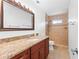 Bathroom with granite countertop, wood cabinets, and a shower at 180 Aurora Rd, Venice, FL 34293