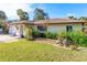 Landscaped front yard with mature trees and rock garden at 180 Aurora Rd, Venice, FL 34293