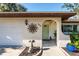 Front entrance of the house featuring a light green door and sun-shaped decor at 180 Aurora Rd, Venice, FL 34293