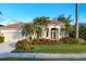 A tan house with palm trees and a manicured lawn at 2037 Silver Palm Rd, North Port, FL 34288