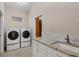 Laundry room with side-by-side washer and dryer, granite countertop, and utility sink at 2037 Silver Palm Rd, North Port, FL 34288