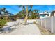 Backyard with gravel ground cover and a white fence at 211 84Th St, Holmes Beach, FL 34217