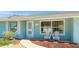 Light teal home exterior with white chairs at 211 84Th St, Holmes Beach, FL 34217