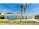 Front view of teal house with landscaping at 211 84Th St, Holmes Beach, FL 34217