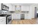 Modern kitchen featuring white shaker cabinets, stainless steel appliances, and gray tile backsplash at 2302 15Th W St, Palmetto, FL 34221