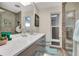 A bathroom featuring a marble countertop vanity, modern fixtures, and gray tiled shower at 320 Avenida Leona, Sarasota, FL 34242