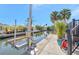 Waterfront canal view with boat lift and lush tropical landscaping along the concrete dock and seawall at 320 Avenida Leona, Sarasota, FL 34242