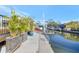 Beautiful waterfront view of the canal with concrete dock and boat lift surrounded by tropical plants at 320 Avenida Leona, Sarasota, FL 34242