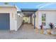 Stylish home entrance featuring a covered walkway, patterned brick path, and minimalist landscaping at 320 Avenida Leona, Sarasota, FL 34242