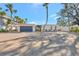 Beautiful exterior view of a home featuring a circular brick driveway, modern architectural details, and tropical landscaping at 320 Avenida Leona, Sarasota, FL 34242