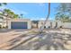 Charming single-story home with a well-manicured brick driveway and simple landscaping, accented by a palm tree at 320 Avenida Leona, Sarasota, FL 34242