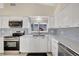 Well-lit modern kitchen with stainless steel appliances, white cabinets, and tiled backsplash at 320 Avenida Leona, Sarasota, FL 34242