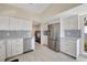 Modern kitchen featuring stainless steel appliances, white cabinets, and a view of the laundry room at 320 Avenida Leona, Sarasota, FL 34242