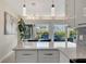 Kitchen island featuring white cabinets, granite countertops, and pendant lighting, with a view to the water at 320 Avenida Leona, Sarasota, FL 34242