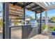 Outdoor kitchen featuring a built-in grill, refrigerator, and countertop space for cooking at 320 Avenida Leona, Sarasota, FL 34242