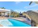 Beautiful pool featuring a dolphin statue and a view of the pergola covered outdoor kitchen at 320 Avenida Leona, Sarasota, FL 34242