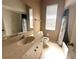 Neutral bathroom featuring a cream vanity, white tile shower, and a window providing natural light at 3409 Branch Creek Dr, Sarasota, FL 34235