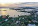 Aerial view of waterfront home with lush landscaping and sunset at 3950 Red Rock Way, Sarasota, FL 34231