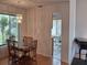 Bright dining room with glass table and six chairs, adjacent to kitchen and screened porch at 4108 Carriage Way # 6, Sarasota, FL 34241