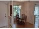 Dining room with a glass-top table and bamboo chairs, and view into kitchen at 4108 Carriage Way # 6, Sarasota, FL 34241