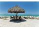 Seating area with thatched umbrella near the ocean at 4503 Coral Lake Dr, Bradenton, FL 34210