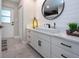 Bathroom with white cabinets, vessel sink, and round mirror at 4517 N Lake Dr, Sarasota, FL 34232