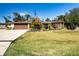 Single-story home with brown garage door, landscaping, and large yard at 4517 N Lake Dr, Sarasota, FL 34232