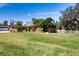 Single-story home with brown garage door, landscaping, and a large yard with white fence at 4517 N Lake Dr, Sarasota, FL 34232