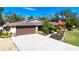 Single story home with brown garage door and a large grassy yard at 4517 N Lake Dr, Sarasota, FL 34232