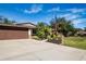 Single-story home with brown garage door, landscaping, and a large yard at 4517 N Lake Dr, Sarasota, FL 34232