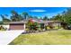 Single-story home with brown garage door, landscaping, and large yard at 4517 N Lake Dr, Sarasota, FL 34232