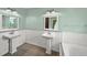 Elegant bathroom with dual pedestal sinks and a bathtub at 4563 Trails Dr, Sarasota, FL 34232