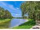 Serene lakefront view with lush landscaping and walking path at 4563 Trails Dr, Sarasota, FL 34232